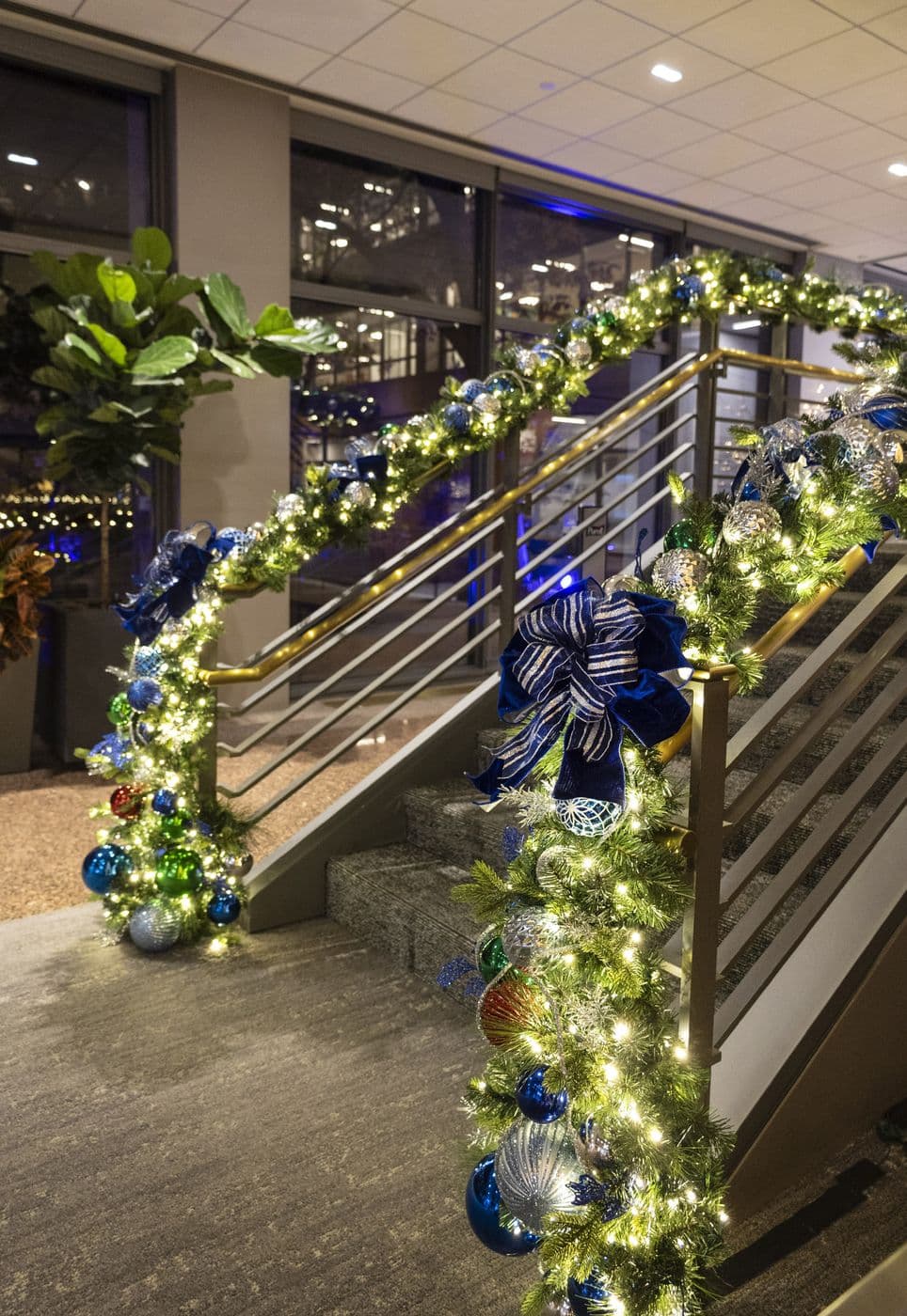 Lit garland in blue and silver running down a modern staircase railing